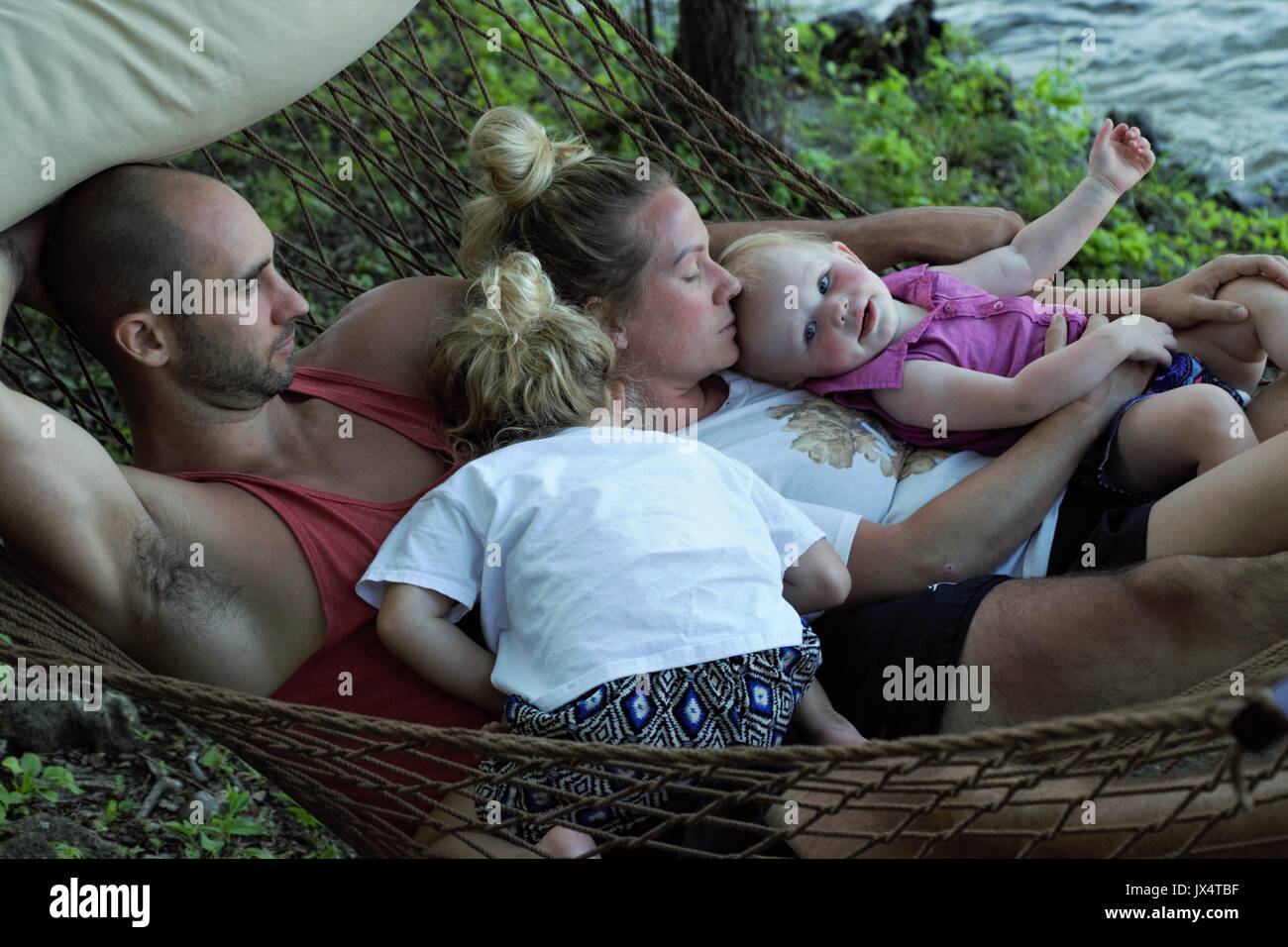 Famille de vous détendre sur un hamac par la rive du lac de l'Ozark, MO Banque D'Images