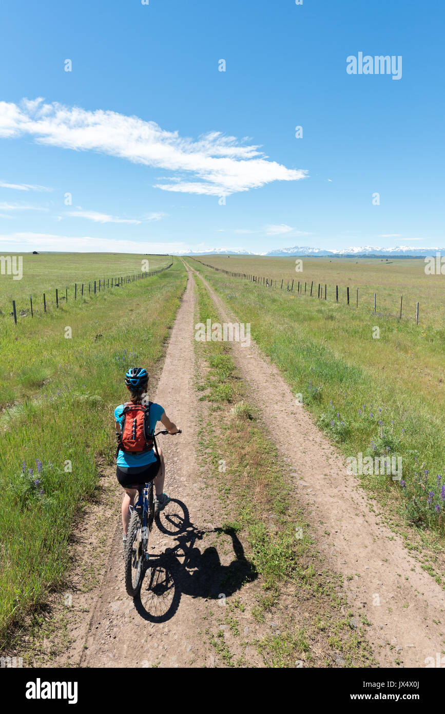 Femme vtt une route sur la Prairie Zumwalt, dans le nord-est de l'Oregon. Banque D'Images