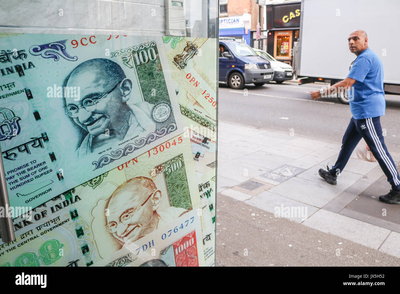 Londres, Royaume-Uni. 15 août 2017. Le visage du fondateur de l'Inde moderne, Mahatma Gandhi sur la couverture des billets de banque indiens à l'extérieur d'un bureau de change boutique à Southall. La communauté indienne et le Pakistan dans l'ouest de Londres de Southall se préparent à commémorer le 70e anniversaire de l'Inde et le Pakistan de l'époque coloniale indepdence Grande-Bretagne en 1947 Credit : amer ghazzal/Alamy Live News Banque D'Images