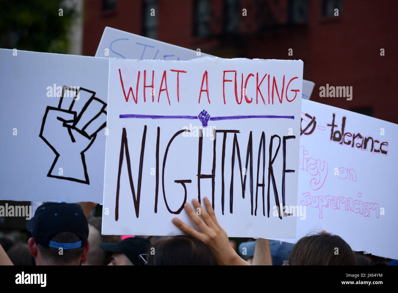Les protestataires holding signs lors d'un rassemblement à New York dénonçant la violence néo-nazie en Virginie et président Trump. Banque D'Images