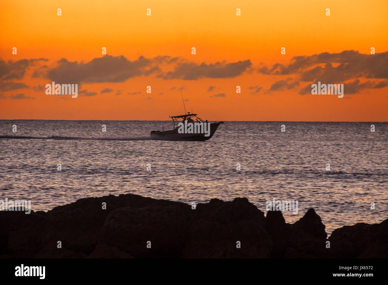 Un bateau au coucher du soleil sur la mer des Caraïbes à la Barbade, les îles des Caraïbes Banque D'Images
