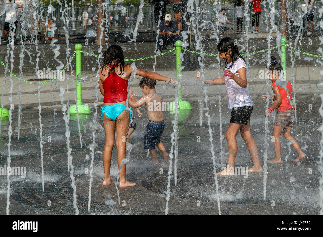 Les enfants obtiennent trempé tout en jouant avec une fontaine au cours d'une chaude journée d'été. Banque D'Images