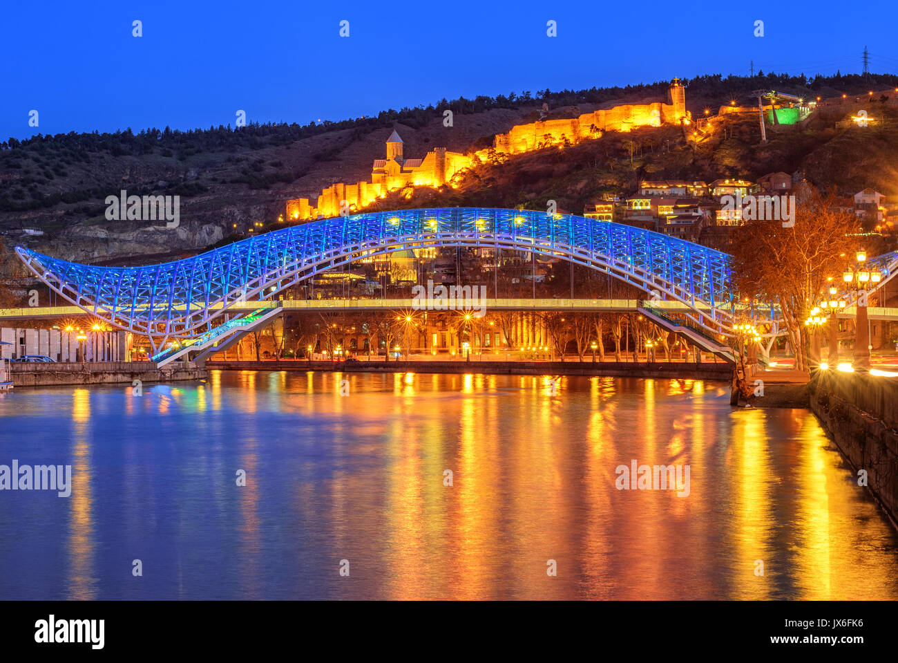 La vieille ville de Tbilissi avec le pont éclairé de la paix sur la rivière Kura et forteresse de Narikala soirée, Géorgie Banque D'Images