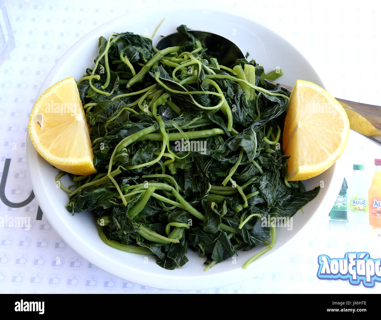 Salade grecque avec des verts sauvages, le pissenlit, les citrons et l'huile d'olive extra vierge Banque D'Images