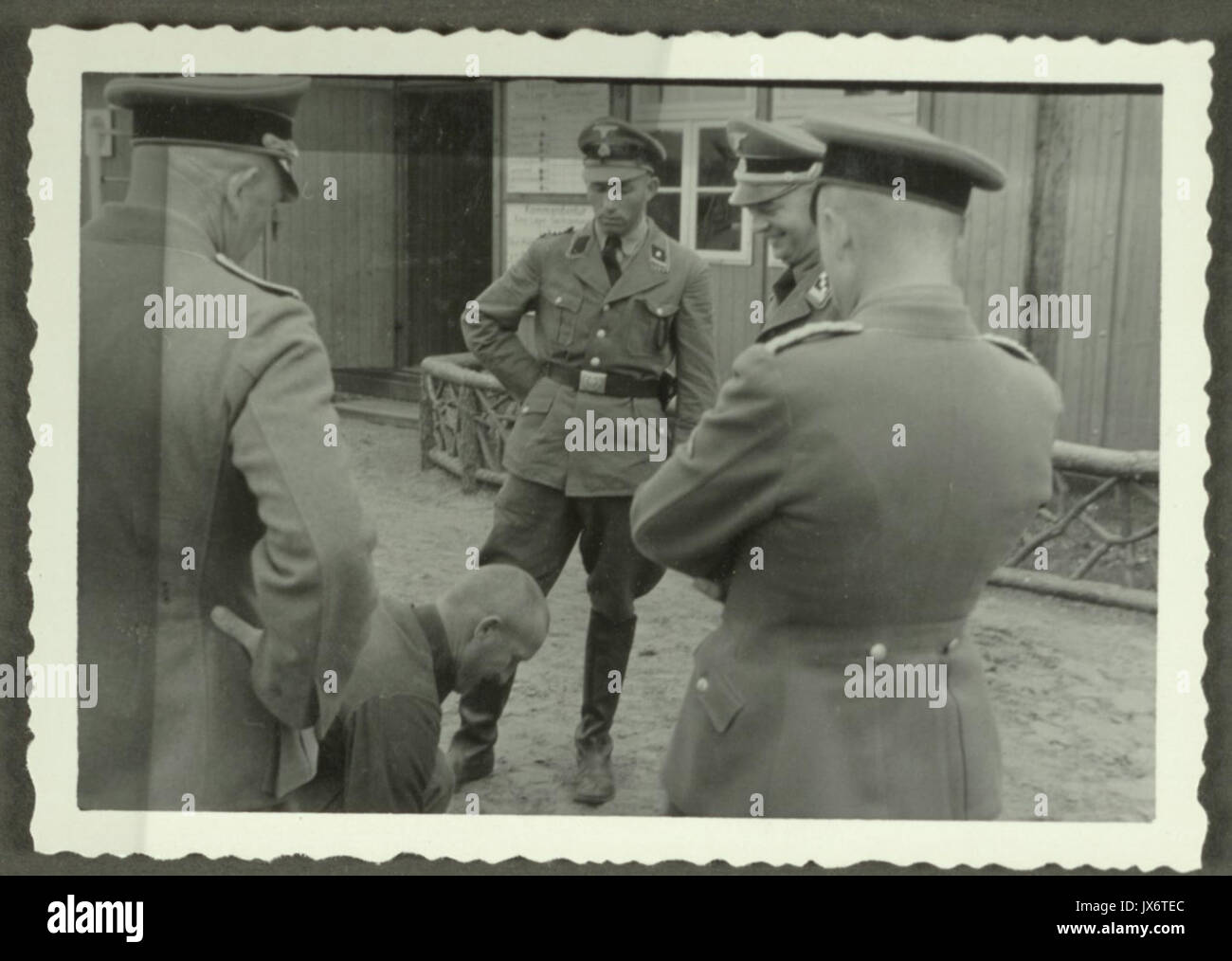 Ein KZ Sachsenhausen Insasse kniet vor vier SS Schergen, darunter Kommandant Karl Otto Koch Banque D'Images