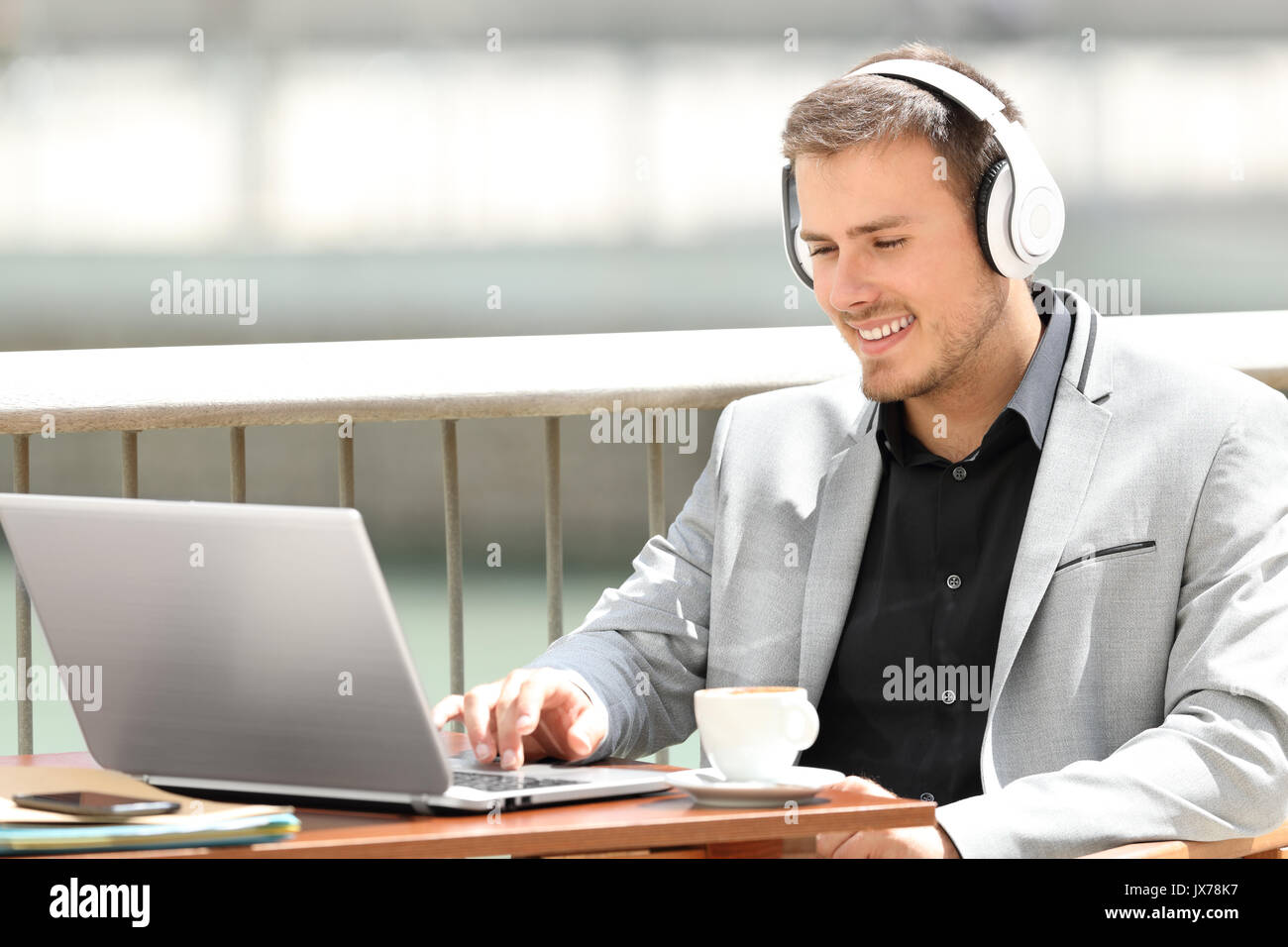 Portrait d'un exécutif portant des écouteurs à la ligne de travail assis dans un café Banque D'Images