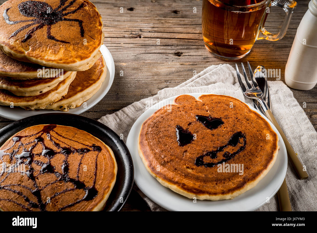 Idées pour le petit déjeuner sont Halloween, les aliments pour enfants. Crêpes à la citrouille décorée avec du sirop de chocolat dans un style traditionnel - araignée, spider, Banque D'Images