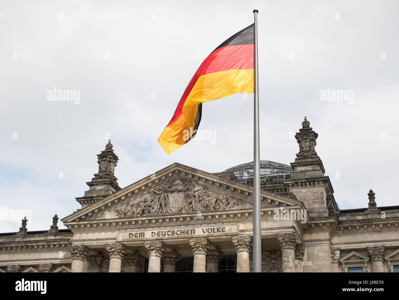 Le drapeau allemand battant devant le bâtiment du Reichstag à Berlin, Allemagne. Banque D'Images