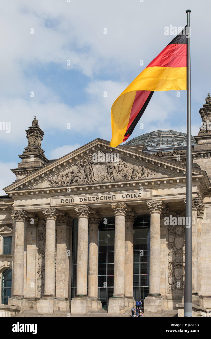 Le drapeau allemand battant devant le bâtiment du Reichstag à Berlin, Allemagne. Banque D'Images