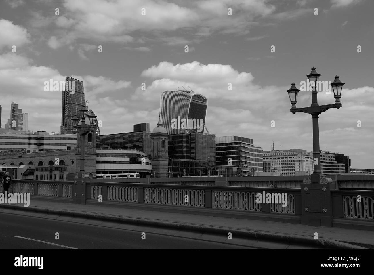 La vue de Southwark Bridge montrant un train de quitter Cannon Street Station, et les gratte-ciel de Londres en arrière-plan. Banque D'Images