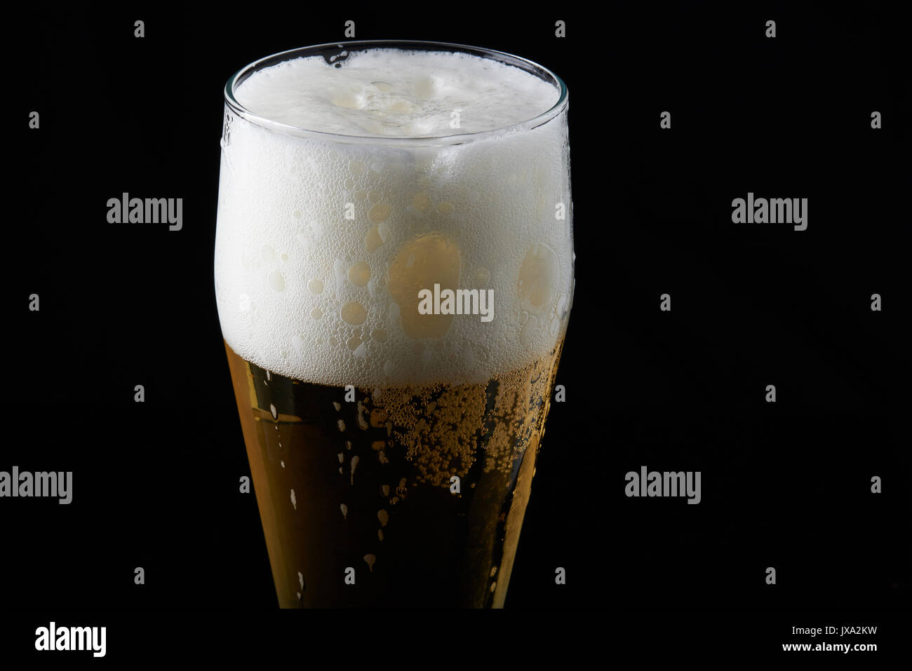 Close-up de mousse de bière en verre isolé sur fond noir Banque D'Images