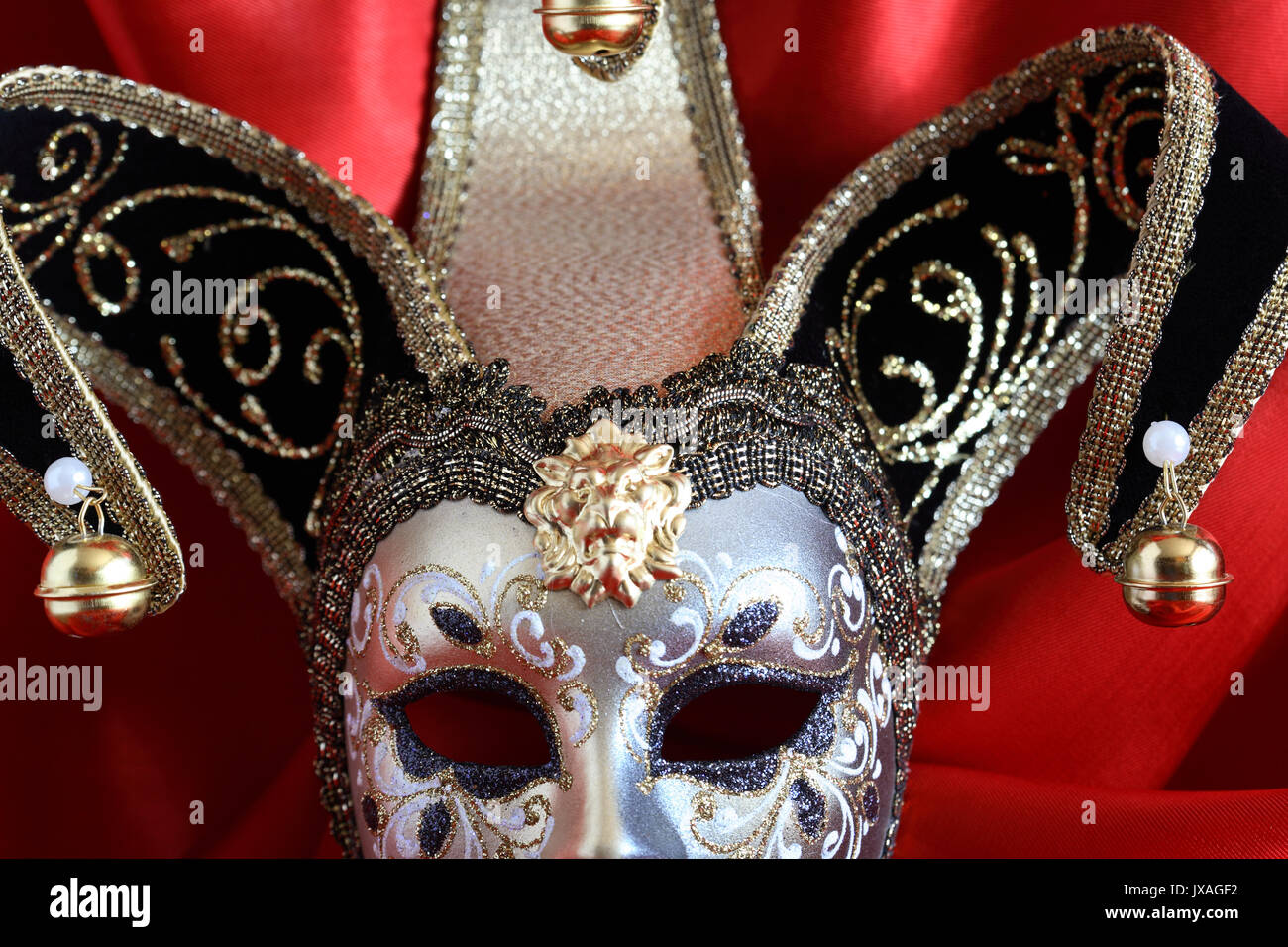 Gros plan du masque vénitien classique sur fond de soie rouge Banque D'Images