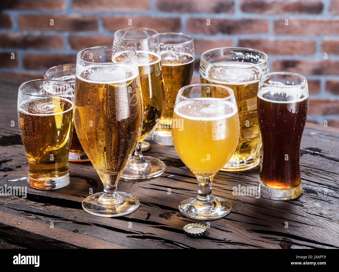 Différents verres de bière sur la table en bois. Banque D'Images