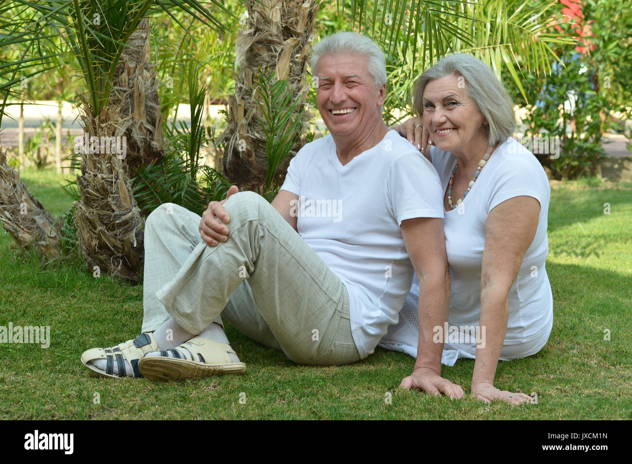 Senior couple sitting on grass Banque D'Images
