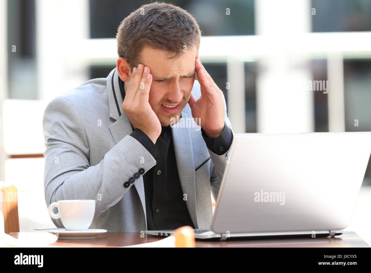 Fatigué de la souffrance à la ligne de tête ache assis dans un café Banque D'Images