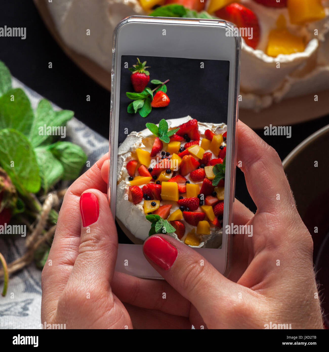 Prise de photos Pavlova gâteau sur le téléphone Banque D'Images