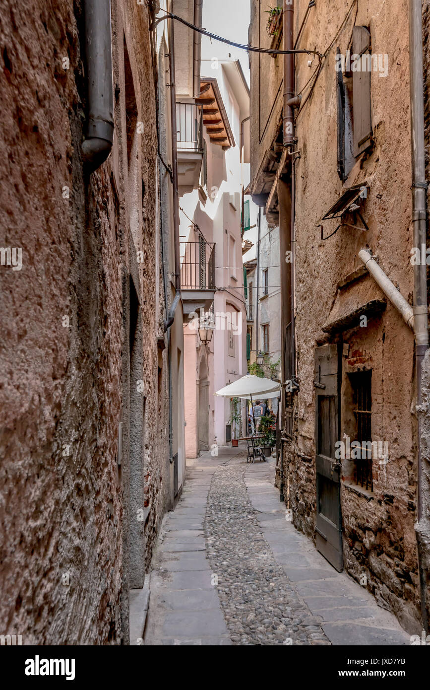 Flexion en étroite ruelle village touristique historique, abattu en journée d'été lumineux à Orta San Giulio, Novara, Cusio, Italie Banque D'Images