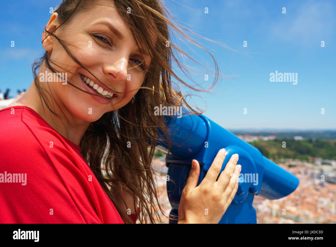 Belle femme tourist en utilisant coin payé jumelles sur colline élevée et à la recherche à cityscape de Nazareth, Portugal Banque D'Images