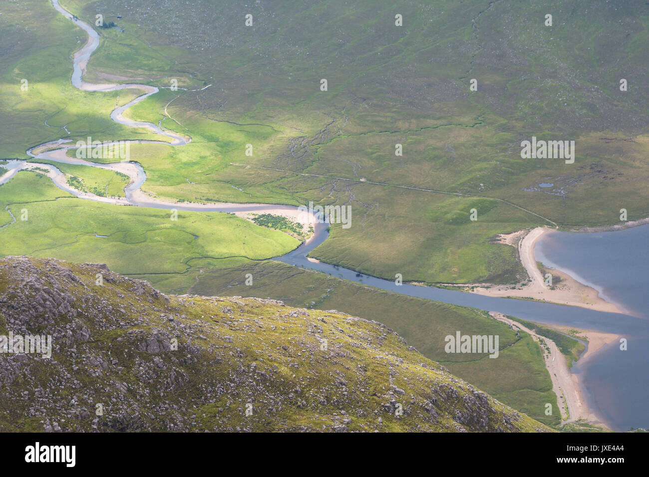 Deux rivières de montagne fonctionnant en bas dans les vallées montagneuses dans les Highlands écossais inscrivez-vous ensemble dans un champ de tourbe et de bruyère avant d'entrer dans la Banque D'Images