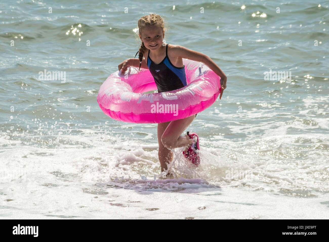 West Bay, Dorset, UK. 15 août, 2017. Météo France : les habitants et les vacanciers profitez d'une chaude après-midi ensoleillée à bronzer et nager à la station balnéaire de West Bay. Crédit Photo : Guy Josse/Alamy Live News Banque D'Images