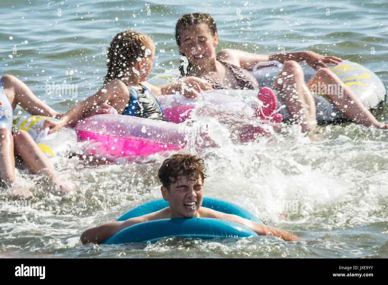 West Bay, Dorset, UK. 15 août, 2017. Météo France : les habitants et les vacanciers profitez d'une chaude après-midi ensoleillée à bronzer et nager à la station balnéaire de West Bay. Crédit Photo : Guy Josse/Alamy Live News Banque D'Images