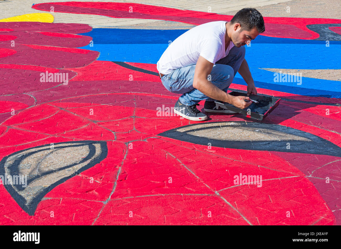 Bournemouth, Dorset, UK. Août 15, 2017. Les grandes œuvres de Spiderman tenant une glace prend forme sur l'approche de la jetée, organisé par l'Art et l'Ambassadeur est d'attirer l'attention des visiteurs. Man painting le contour de yeux Spidermans de peinture noire. Credit : Carolyn Jenkins/Alamy Live News Banque D'Images