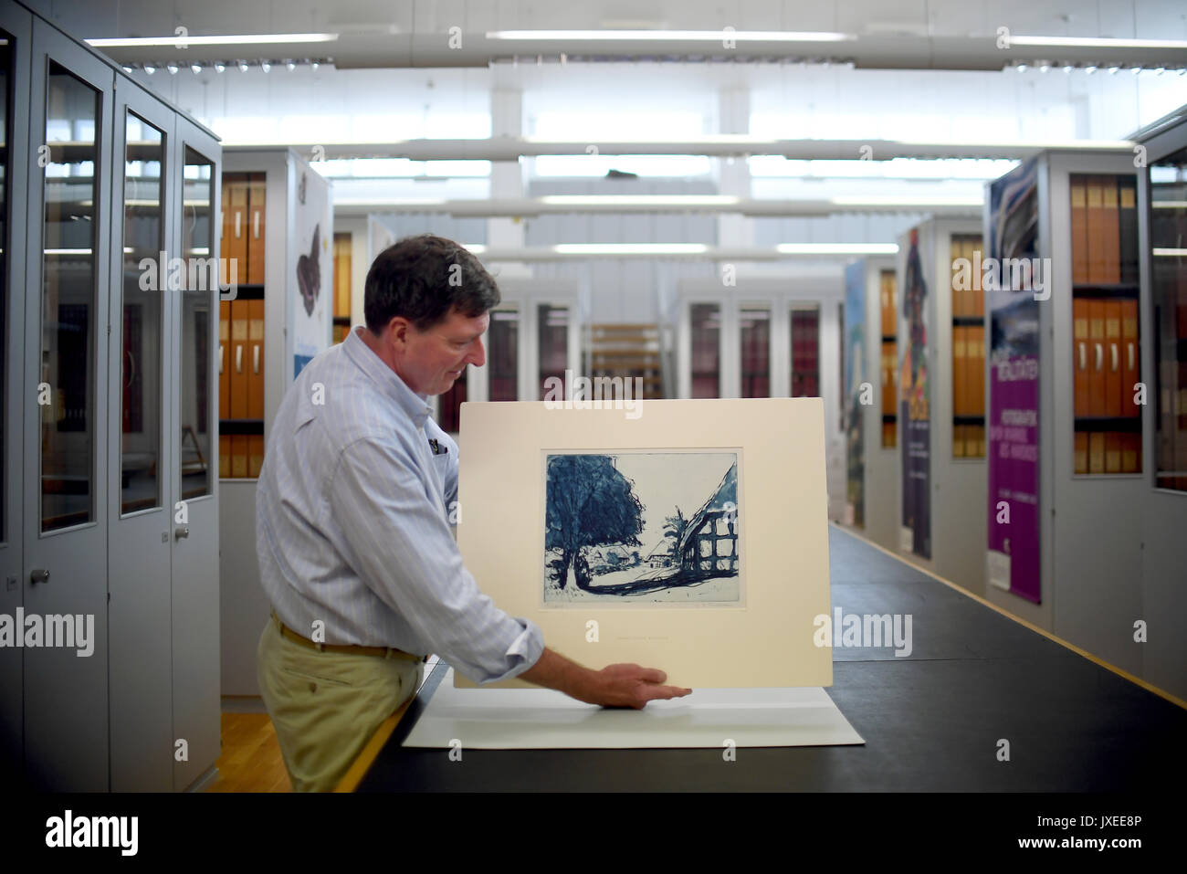 Berlin, Allemagne. Août 15, 2017. Le directeur adjoint de la Berlin Kupferstichkabinett (Musée d'Estampes et dessins), Holm Bevers, détient l'eau-forte Fehmarnhäuser «mit Baum' (1908) (lit. Fehmarn maisons avec grand arbre) de l'artiste Ernst Ludwig Kirchner dans ses mains à Berlin, Allemagne, 15 août 2017. Maintenant, la Fondation du patrimoine culturel prussien a racheté le bleu d'une eau-forte après le retour aux héritiers du collectionneur juif Eugen Moritz Buchtal. Photo : Britta Pedersen/dpa-Zentralbild/dpa/Alamy Live News Banque D'Images