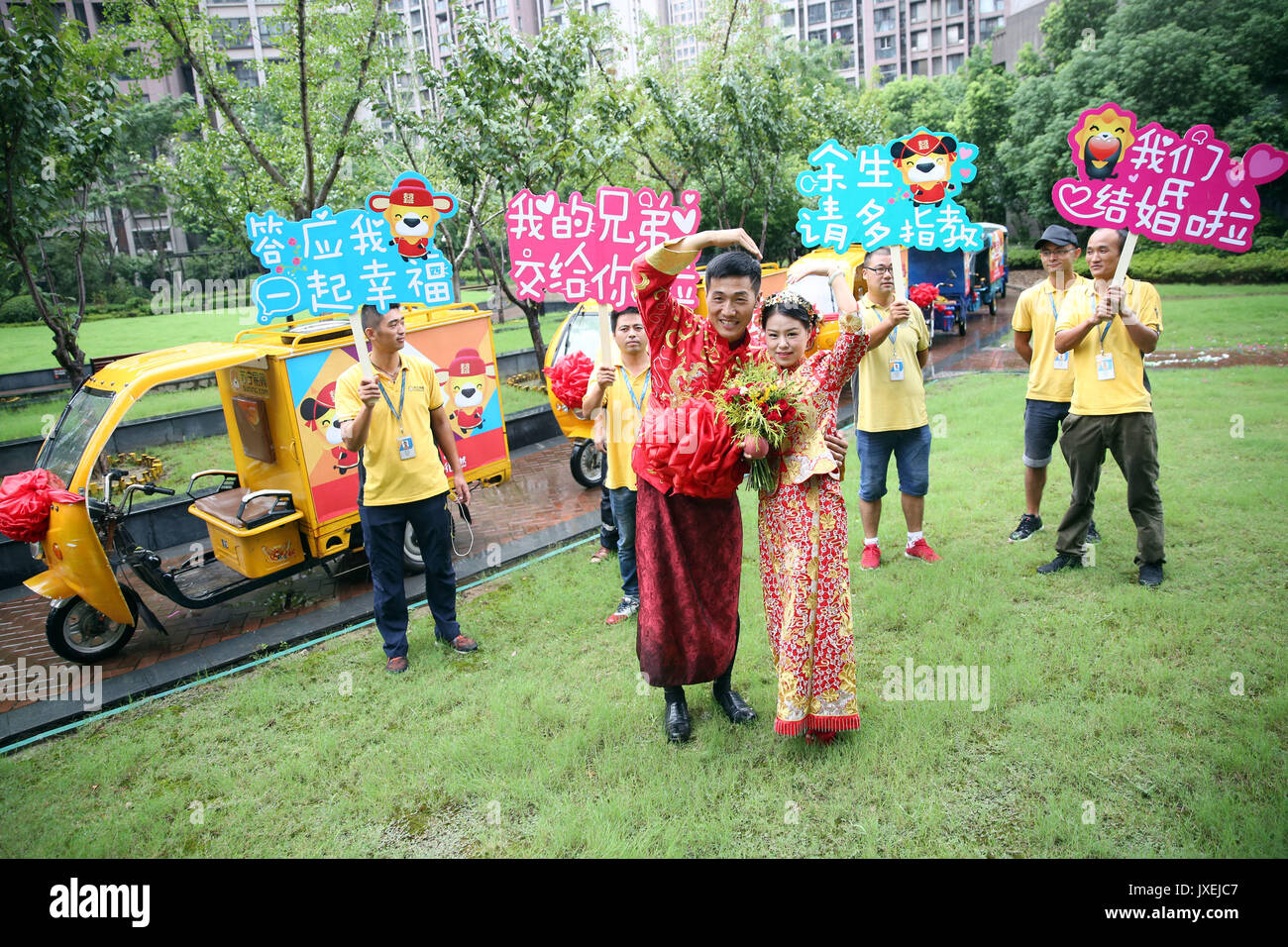 (170816) -- Nanjing, 16 août 2017 (Xinhua) -- l'époux Xu et son épouse posent pour des photos avec des collègues à Nanjing, capitale de la province de Jiangsu, Chine orientale, le 16 août 2017. Xu fonctionne comme un service de messagerie à l'intérieur et ses collègues ont tenu une cérémonie spéciale pour lui avec les véhicules de livraison. (Xinhua/Li Yuze) (ZHS) Banque D'Images