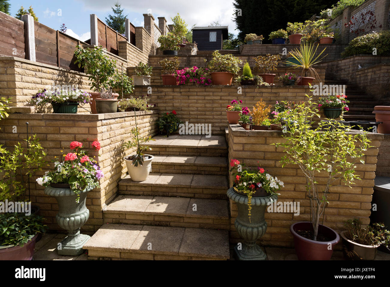 Jardin de banlieue construit avec des murs en brique d'une colline. Solihull Birmingham UK Banque D'Images
