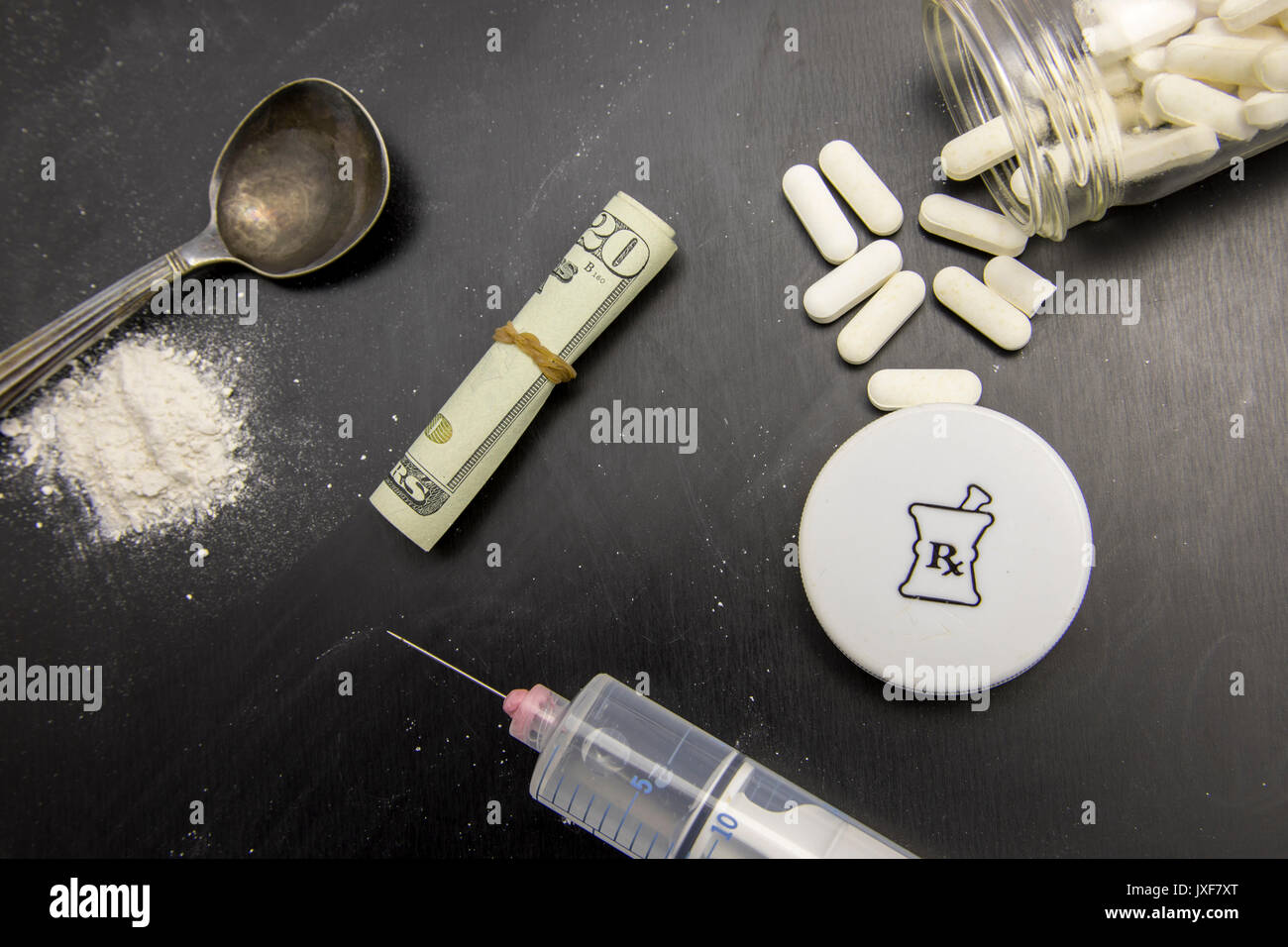 Opiods en comprimé, poudre et d'une seringue on chalkboard à vingt dollars. Banque D'Images