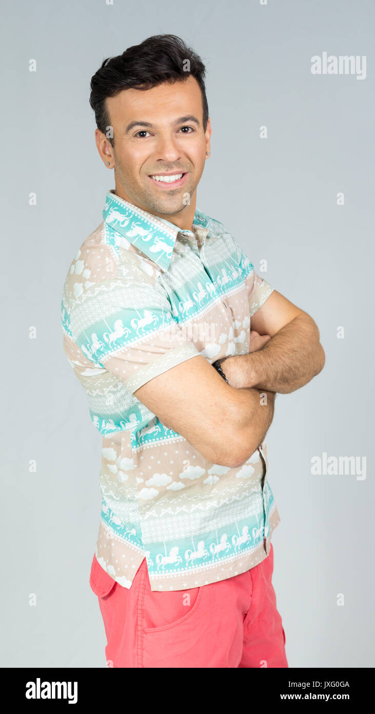Homme avec bras croisés et sourire. Il est confiant et digne de confiance.  Profil. Beau mâle brésilien portant une chemise colorée. L'été, tropical.  30s Photo Stock - Alamy
