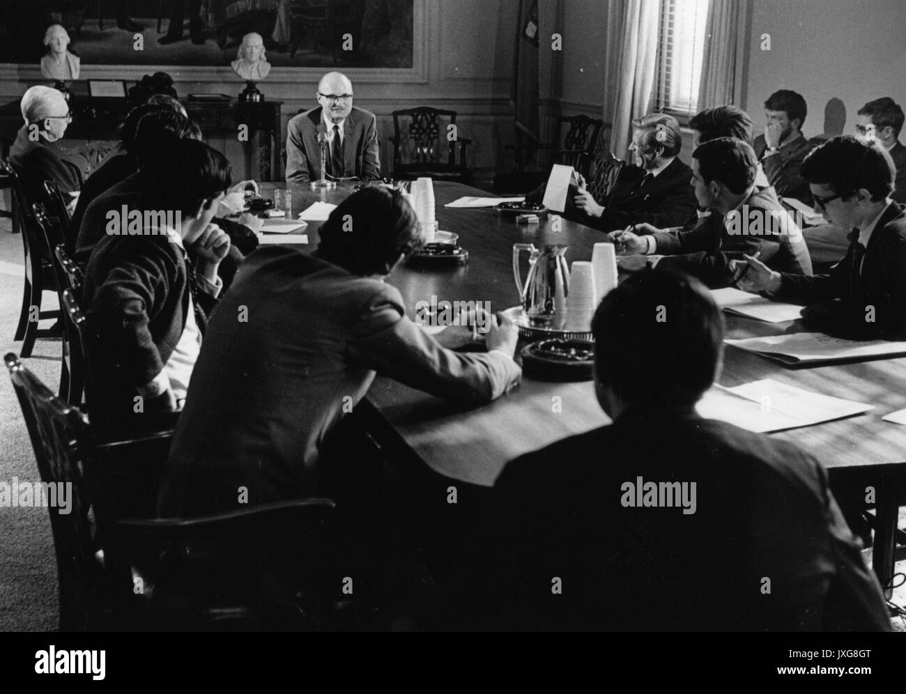 Barth, John Barth, est assis à la tête d'une table entourée par des hommes avec des ordinateurs portables, peut-être lors d'une conférence de presse ou de l'écriture de séminaire, 1967. Banque D'Images