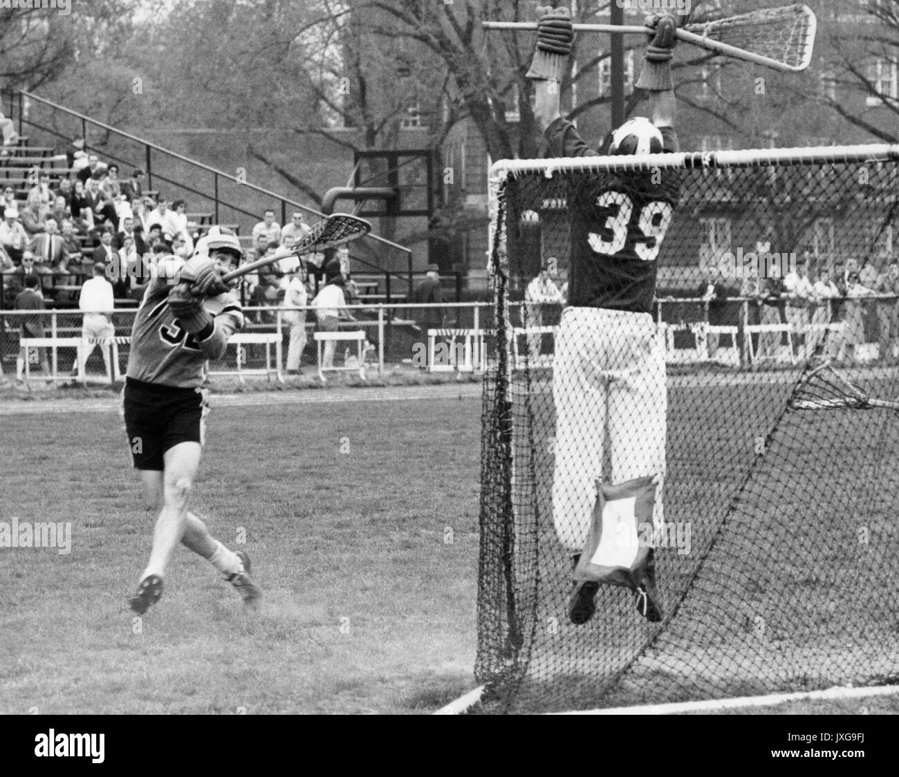 La crosse photo d'action prises au cours d'un match de crosse non identifiés de Homewood campus, un membre de l'équipe adverse s'efforce de rendre un but, alors que le gardien de but semble d'attraper la balle, 1950. Banque D'Images