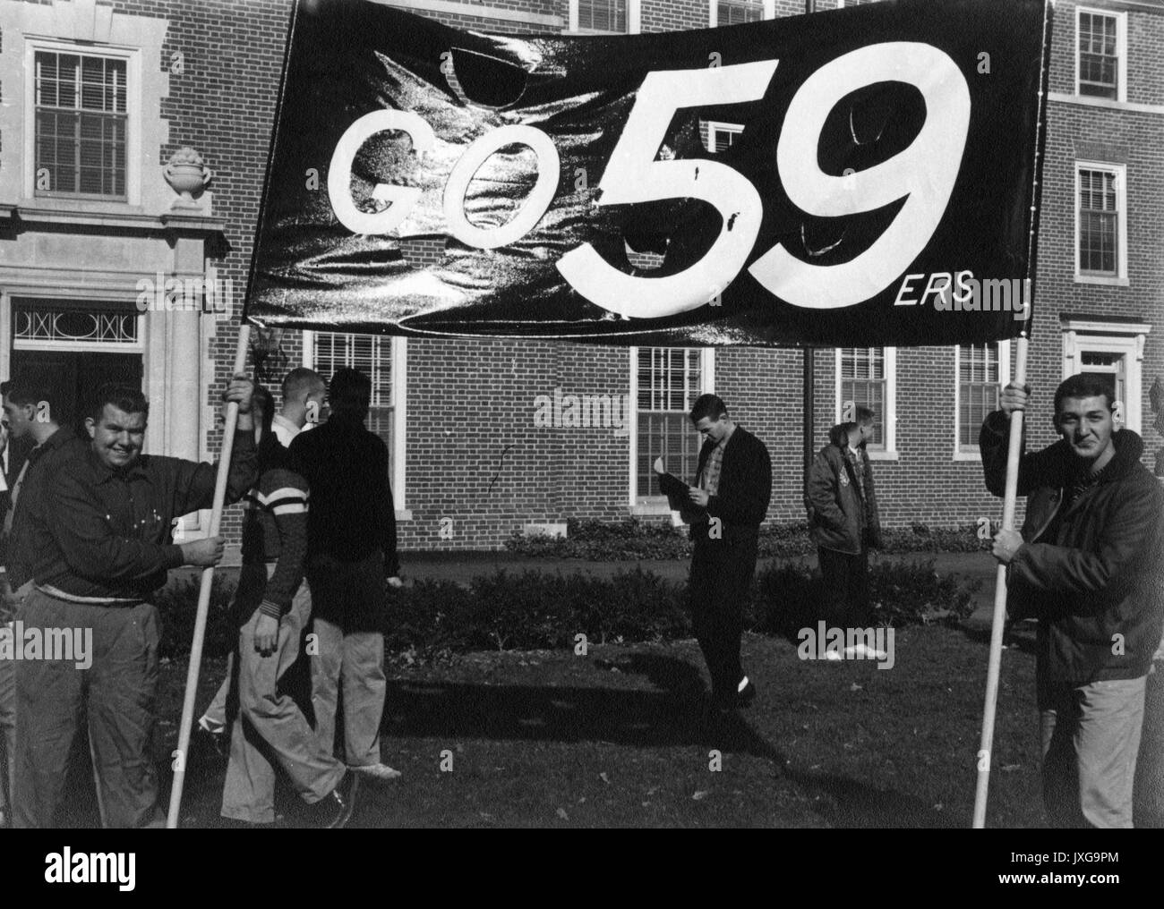 La vie étudiante deux freshmen sont porteurs du rendez-vous 59ers freshmen banner, 1955. Banque D'Images