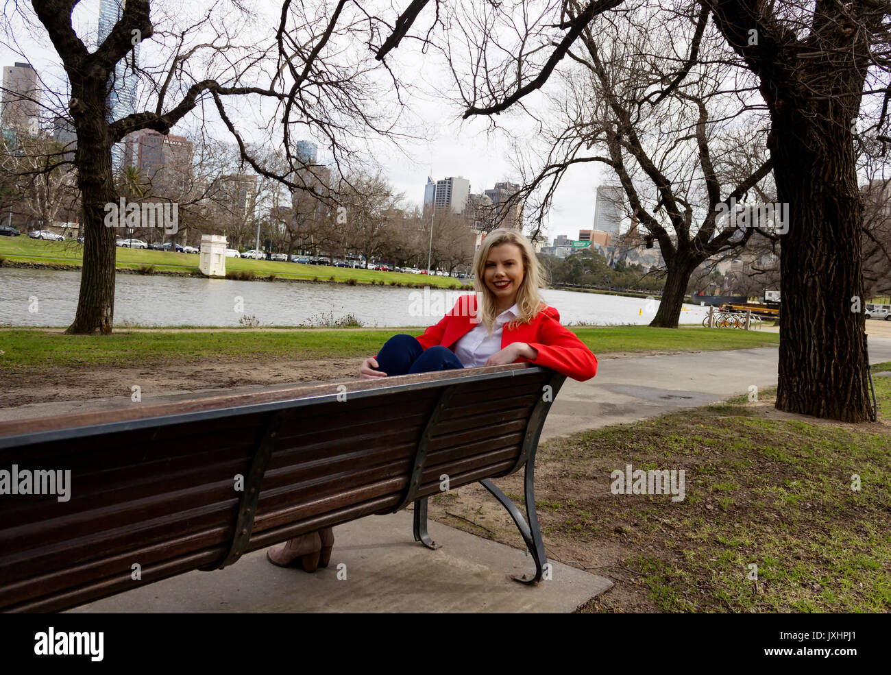 Girl posing in park, attraper son relfections dans la flaque ci-dessous. Banque D'Images