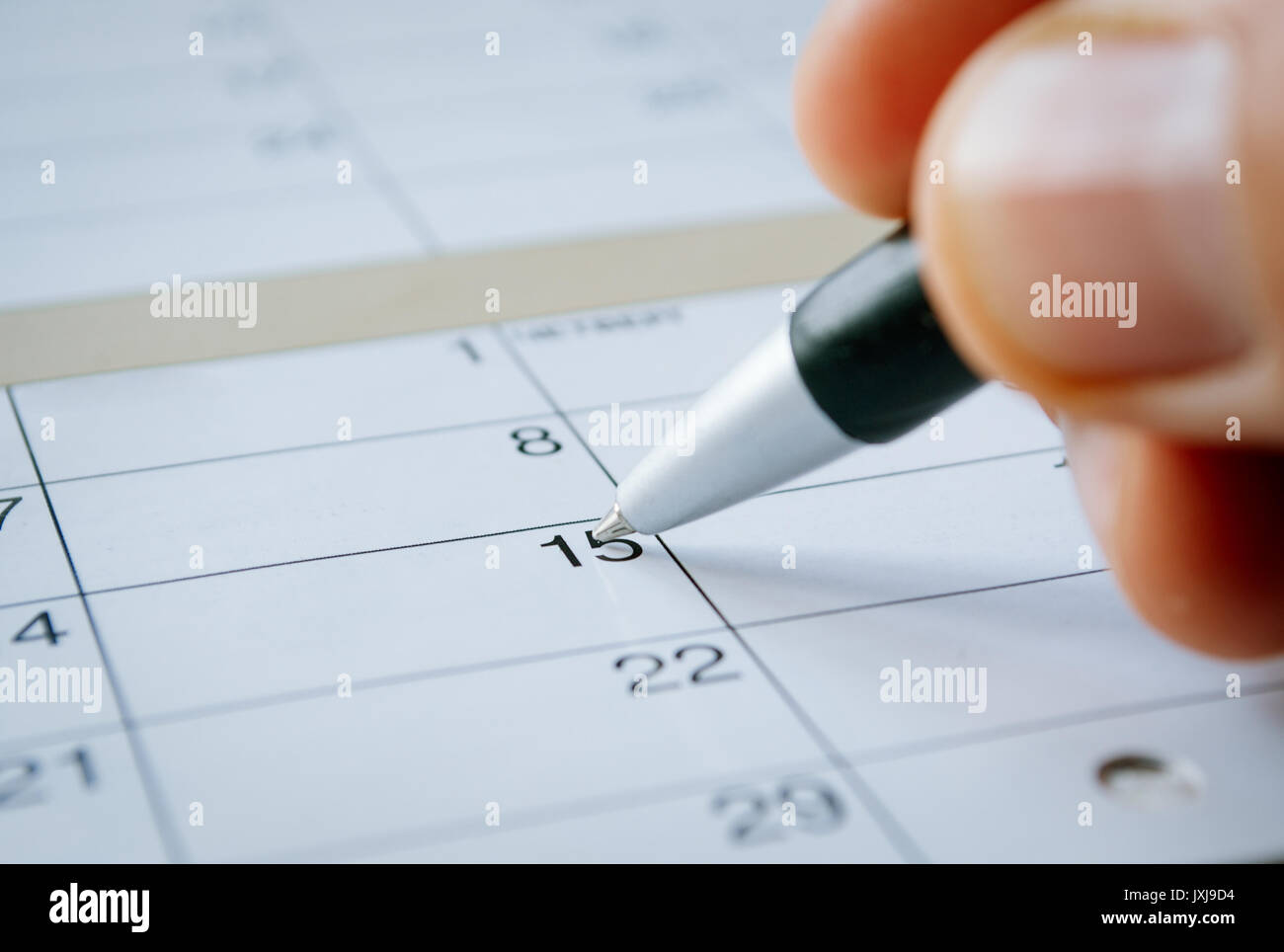 Personne Qui Ecrit Avec Un Stylo Sur Un Agenda A La Date Du 15e Avec La Graine Planant Au Dessus De Vide Copyspace Angle Oblique Photo Stock Alamy
