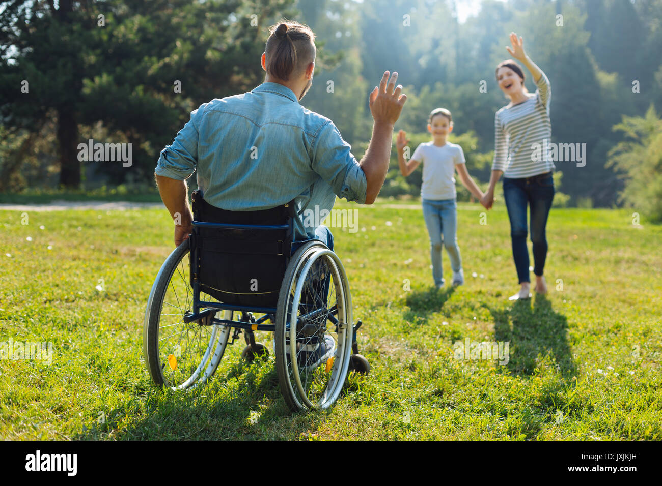 Jeune homme ayant une déficience forme bonjour à sa famille Banque D'Images