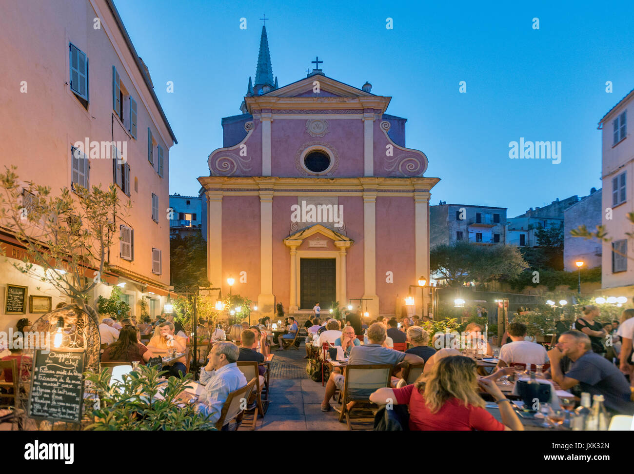 Restaurant en plein air à l'heure bleue, près de l'église Sainte Marie à Calvi, dans le nord de la ville Corse, France Banque D'Images