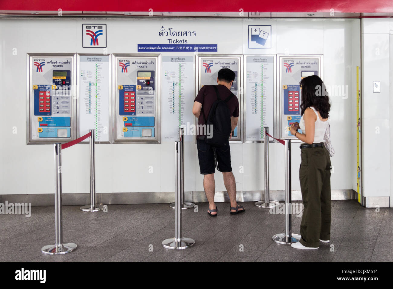 L'homme et la femme se des billets à partir de la machine de billets à la station de BTS Skytrain Asoke, Bangkok, Thaïlande Banque D'Images