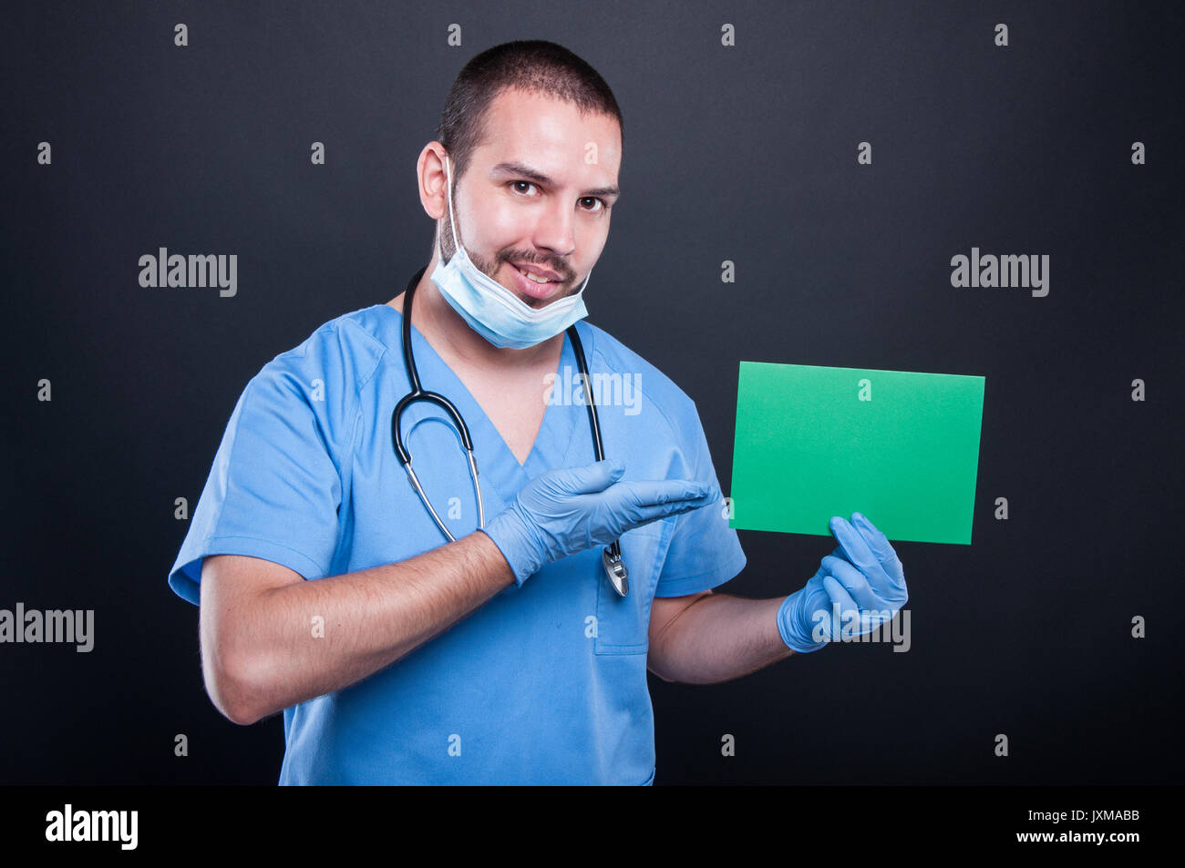 Doctor holding et montrant une carte verte copypsace sur fond noir avec de l'espace texte copie Banque D'Images