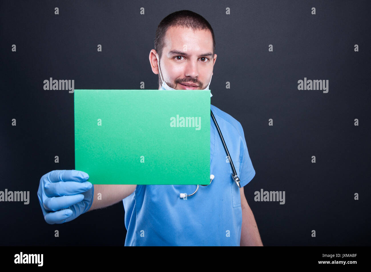 Medic holding et montrant une carte copypsace vert sur fond noir avec de l'espace texte copie Banque D'Images