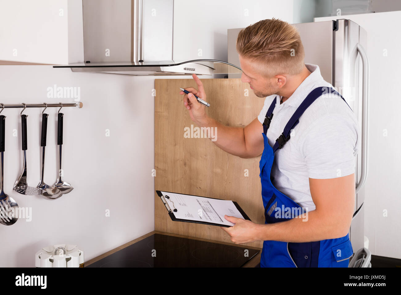 Réparateur de jeunes hommes avec presse-papiers filtre contrôle Extracteur de cuisine Banque D'Images