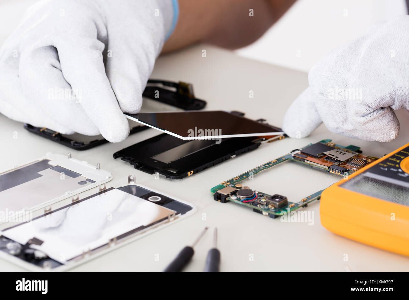 Close-up of Person's Hand fixant écran endommagé sur téléphone mobile Banque D'Images