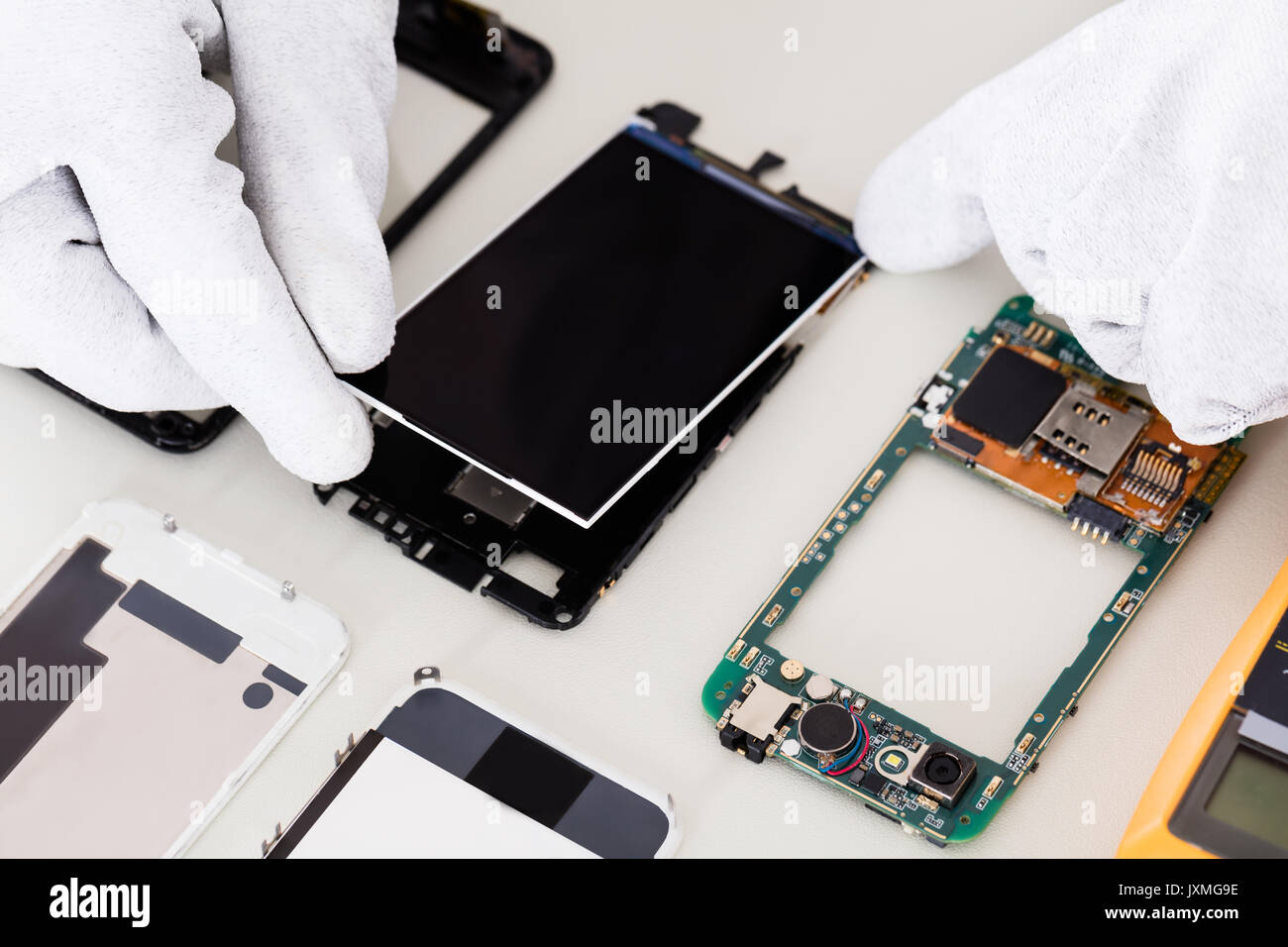 Close-up of Person's Hand fixant écran endommagé sur téléphone mobile Banque D'Images