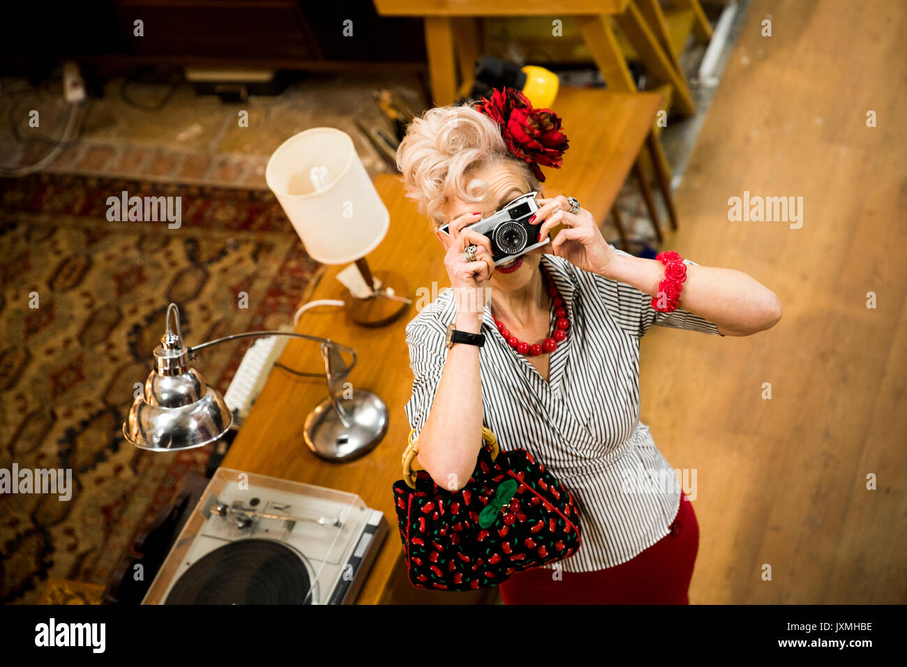 Femme excentrique de prendre des photos sur l'appareil photo vintage en antiquités emporium Banque D'Images