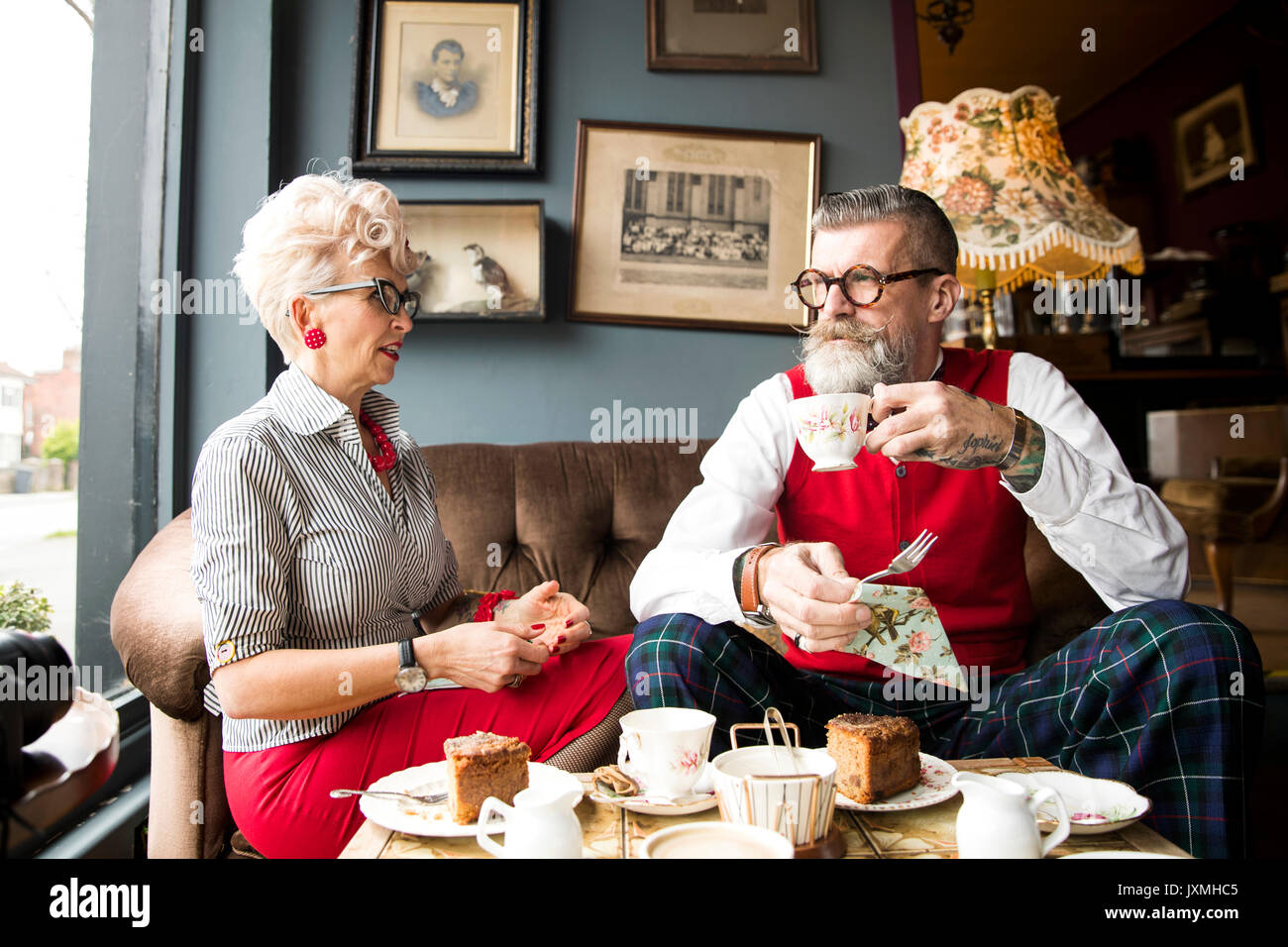 Quirky vintage couple drinking tea in salon de thé Banque D'Images