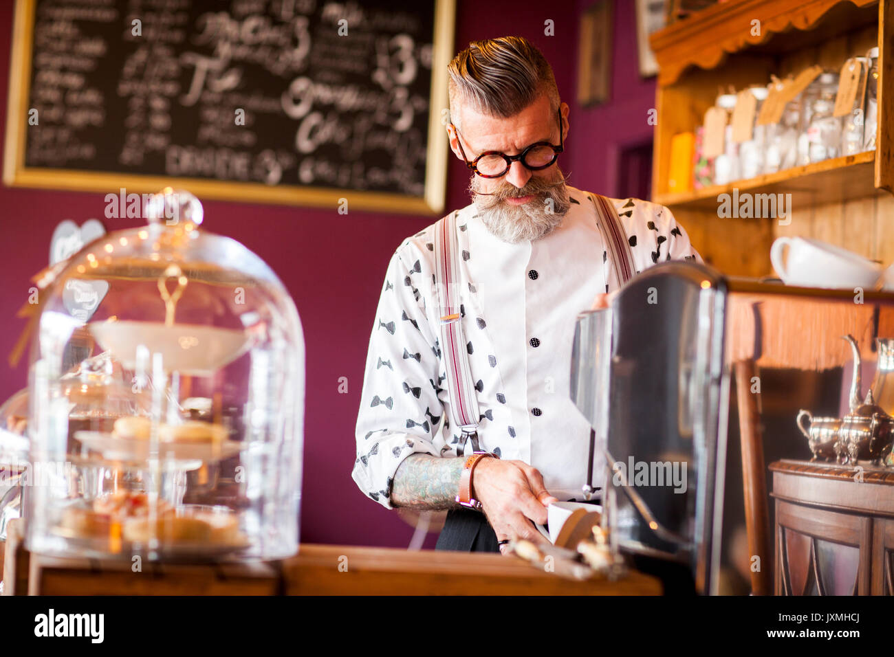 Vintage original man à l'aide d'une machine à café dans un salon de thé Banque D'Images
