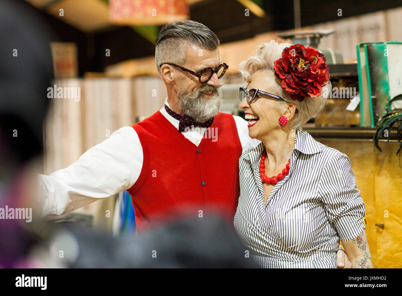 Quirky vintage couple laughing and in antique emporium Banque D'Images