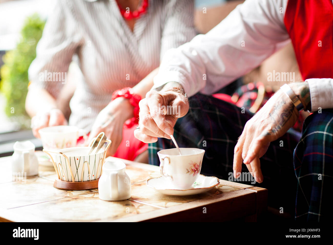Close up of hands of senior man en remuant dans vintage tea rooms Banque D'Images