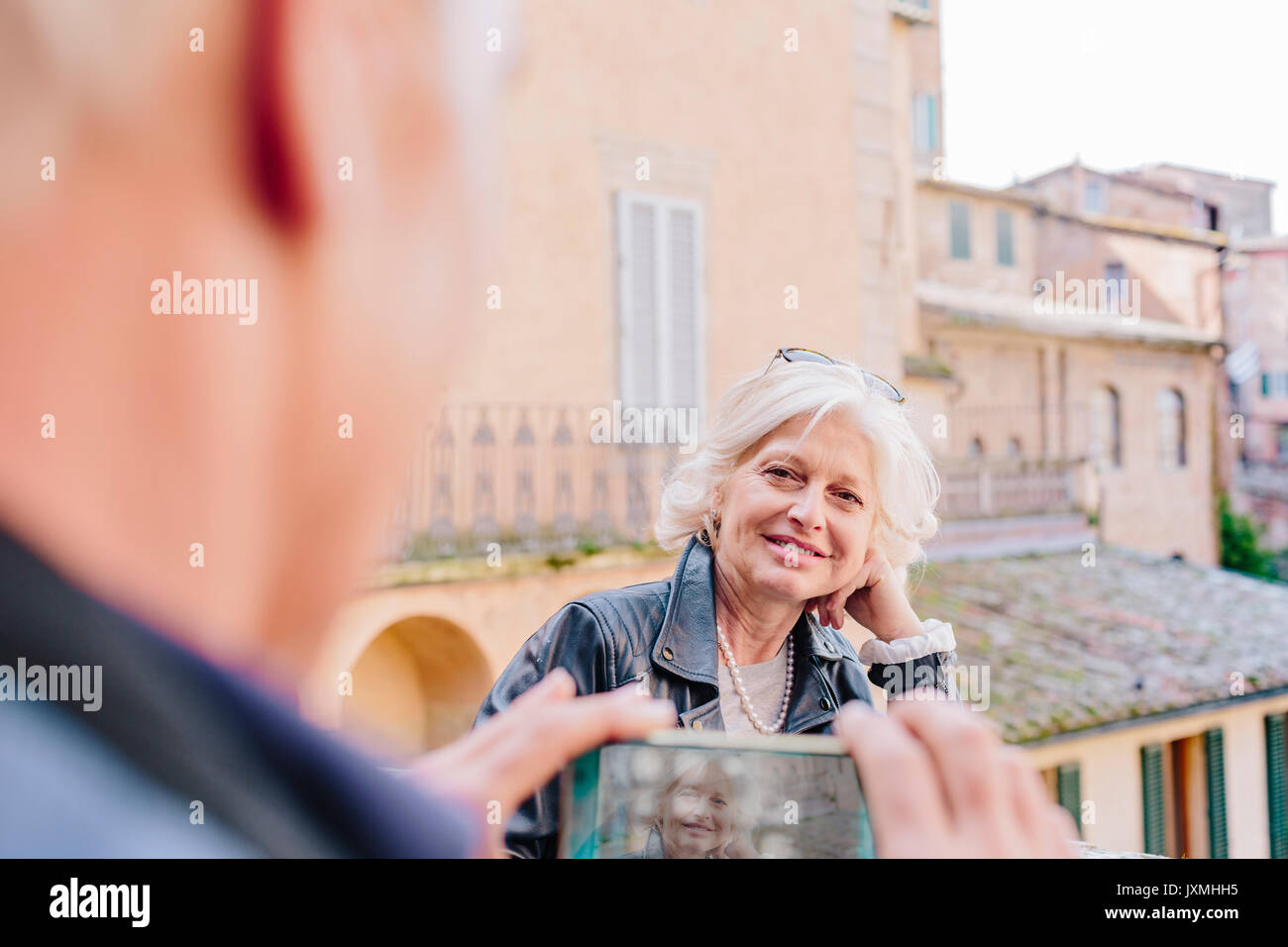 Plus d'épaule d'hommes photographing wife en ville, Sienne, Toscane, Italie Banque D'Images